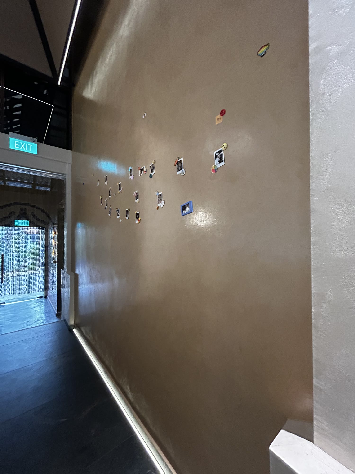 Corridor wall at SHAO Dempsey finished in Armourcoat Perlata over Smarter Surfaces magnetic plaster, with photographs held up by magnets