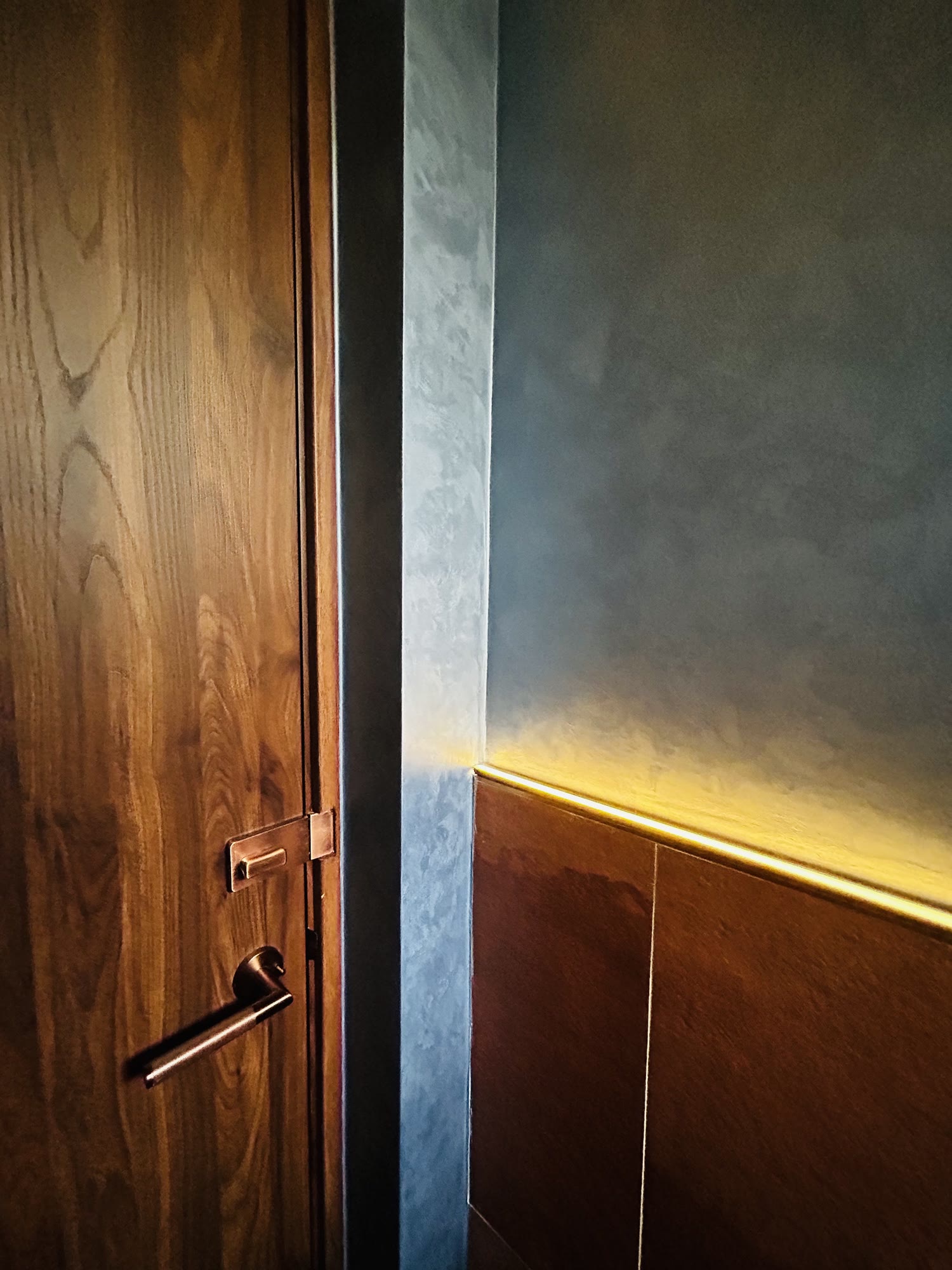 Armourcoat finish on a washroom wall at SHAO Dempsey, lit by a concealed LED strip
